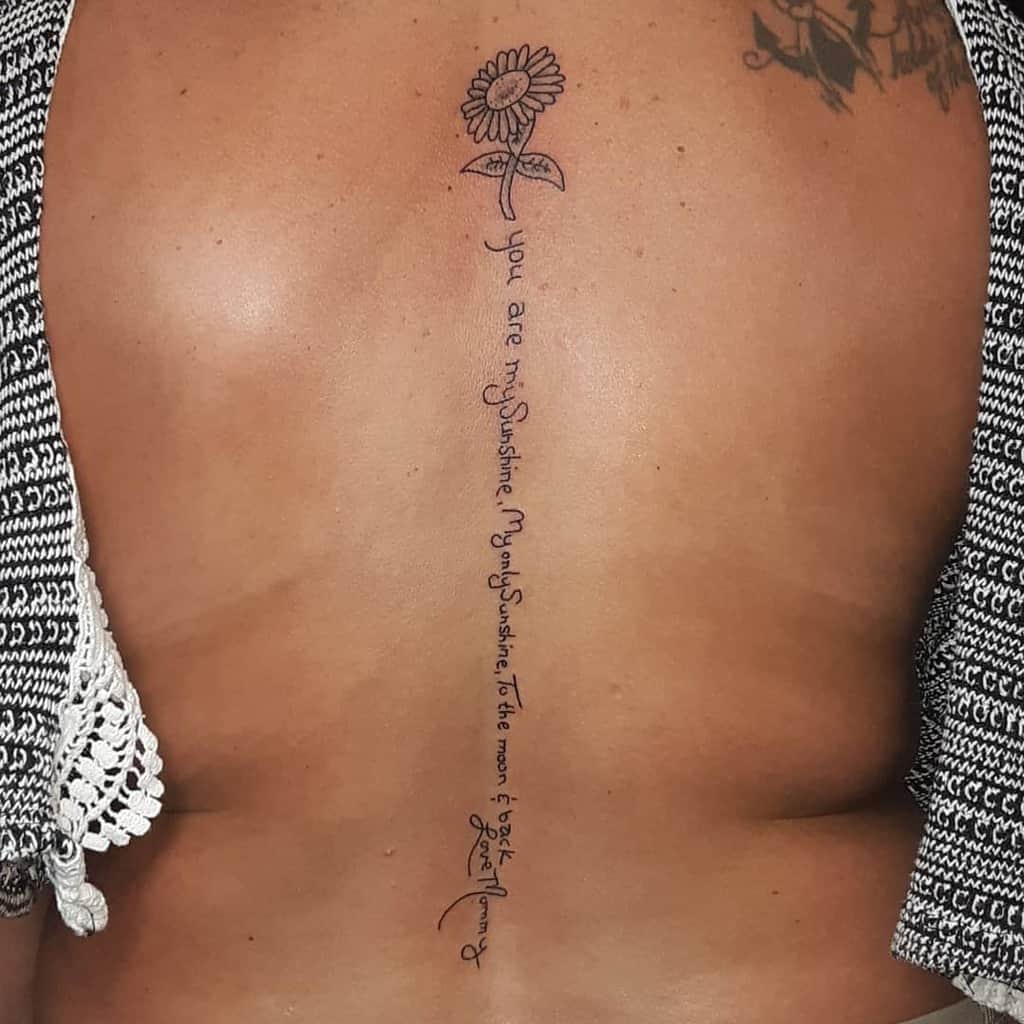 Back tattoo of a sunflower and "You are my sunshine" text