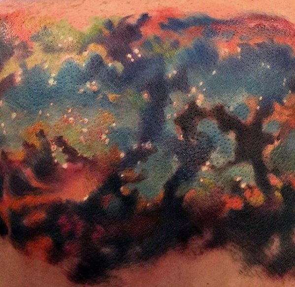Colorful abstract tattoo with vibrant nebula-like blue, green, and orange hues