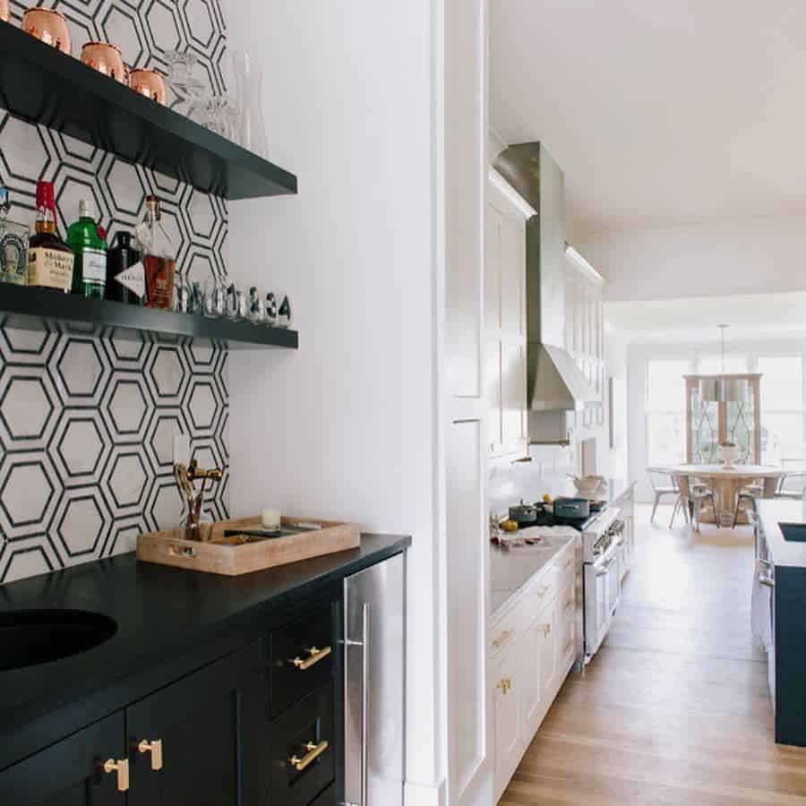Kitchen with hexagonal tile backsplash, black countertop, open shelves, and white cabinets.