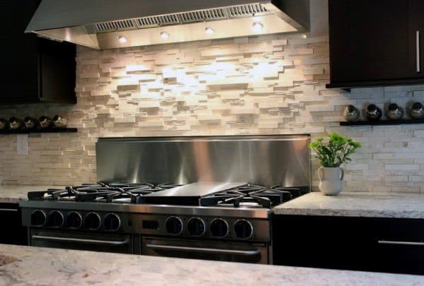 Stacked stone backsplash with under-cabinet lighting adds elegance to the stainless steel range.