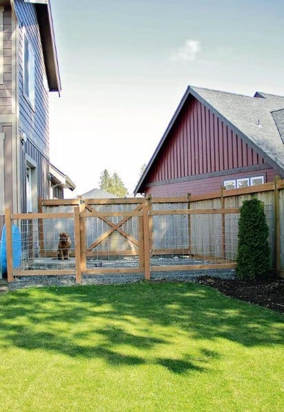 A fenced backyard with a dog by the gate, surrounded by houses and a pristine lawn