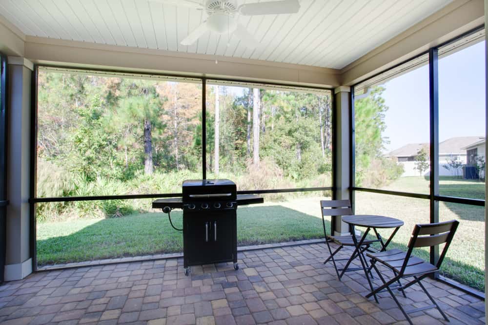 backyard enclosed patio brick paving bbq small wood seat and table 