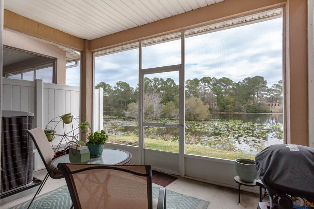 small enclosed patio glass top table and chairs covered bbq lake view