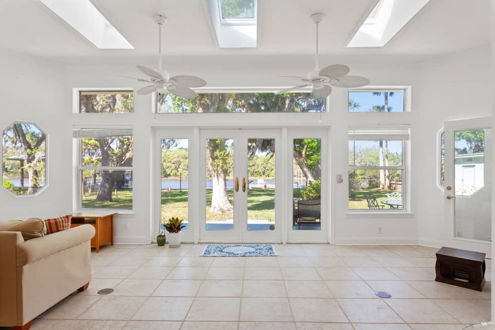 large backyard enclosed patio white walls two ceiling fans paver flooring wall mirror