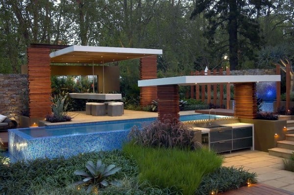 Modern flat-top pavilion with a sleek poolside bar, outdoor kitchen, and dining area in a lush garden.