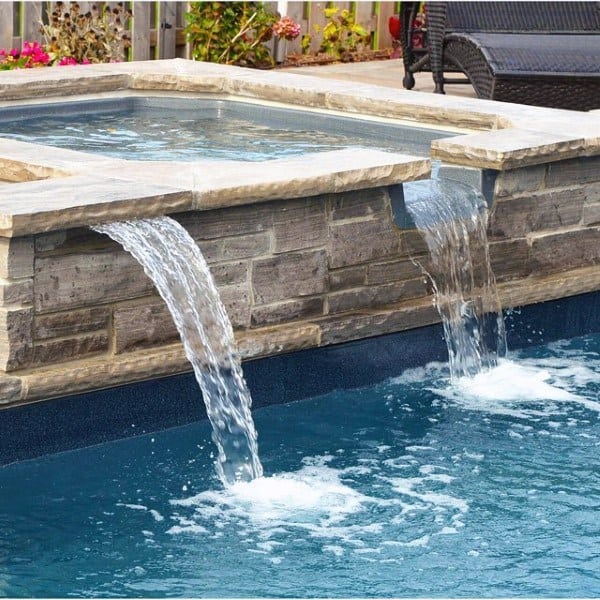Backyard pool with cascading stone waterfalls and an elevated spa feature.