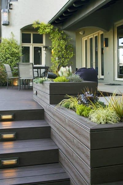Wooden deck with built-in planter boxes, step lighting, and outdoor dining area.