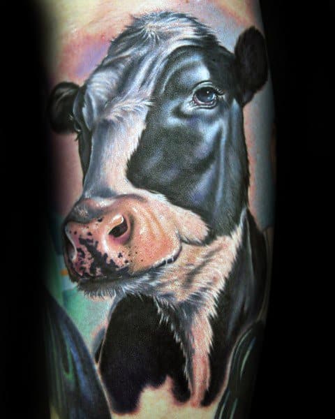 Vivid full-color cow tattoo with lifelike details, featuring soft pink tones and realistic fur texture on a dark background.