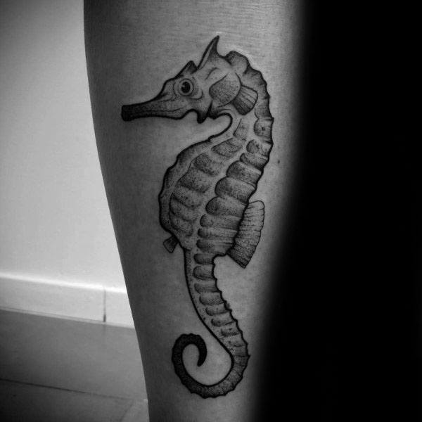 Realistic seahorse tattoo on the leg, featuring bold shading and fine details for a lifelike, textured appearance.
