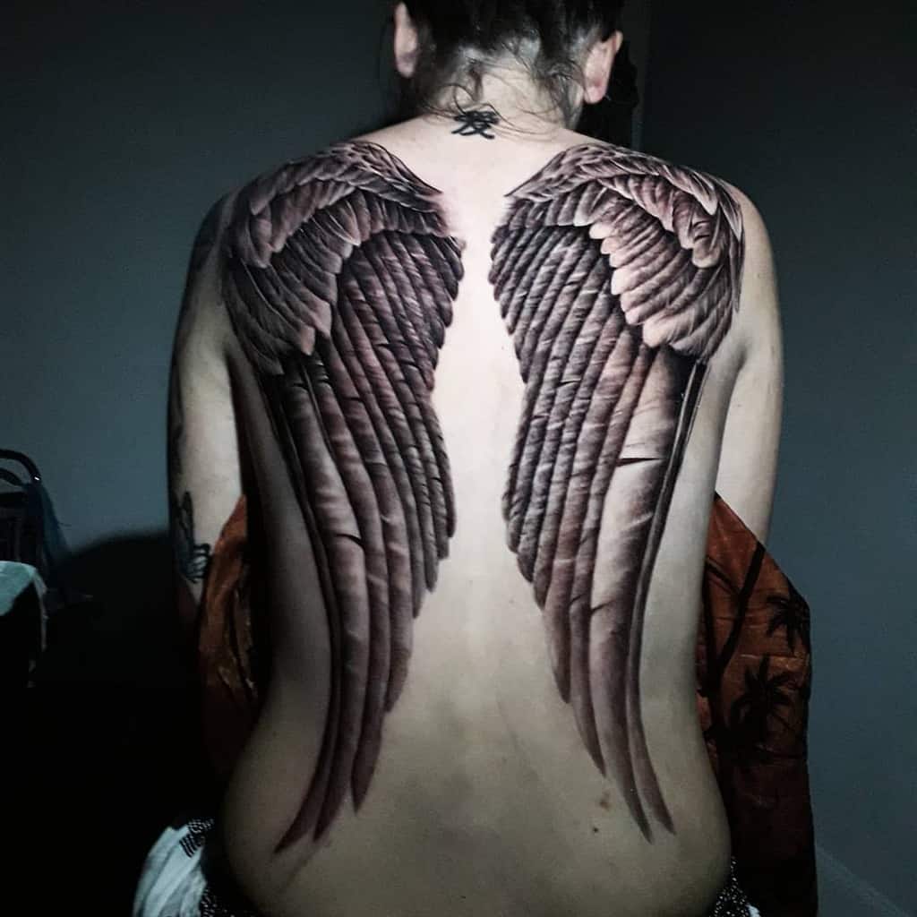A large, detailed angel wing tattoos with intricate shadings and line work