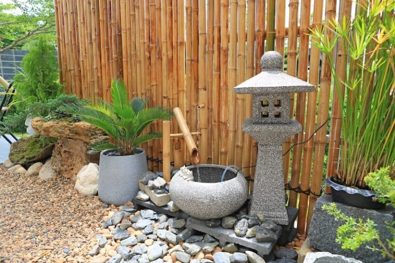 bamboo fence stone statue water feature garden