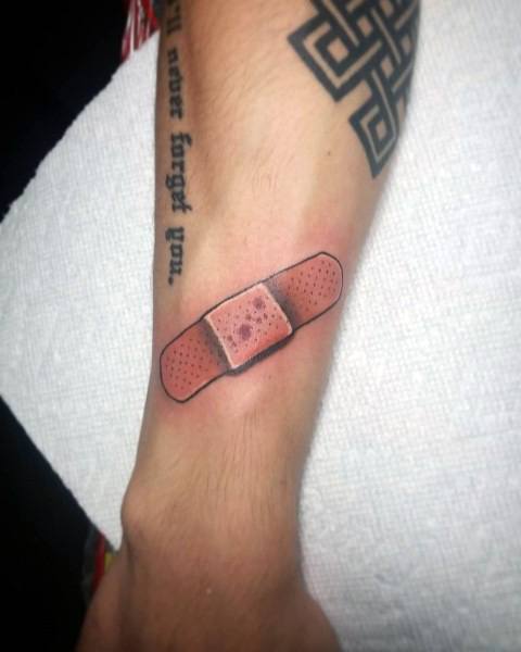 Simple Band-Aid tattoo with a slightly red and irritated center, giving the illusion of healing skin beneath.