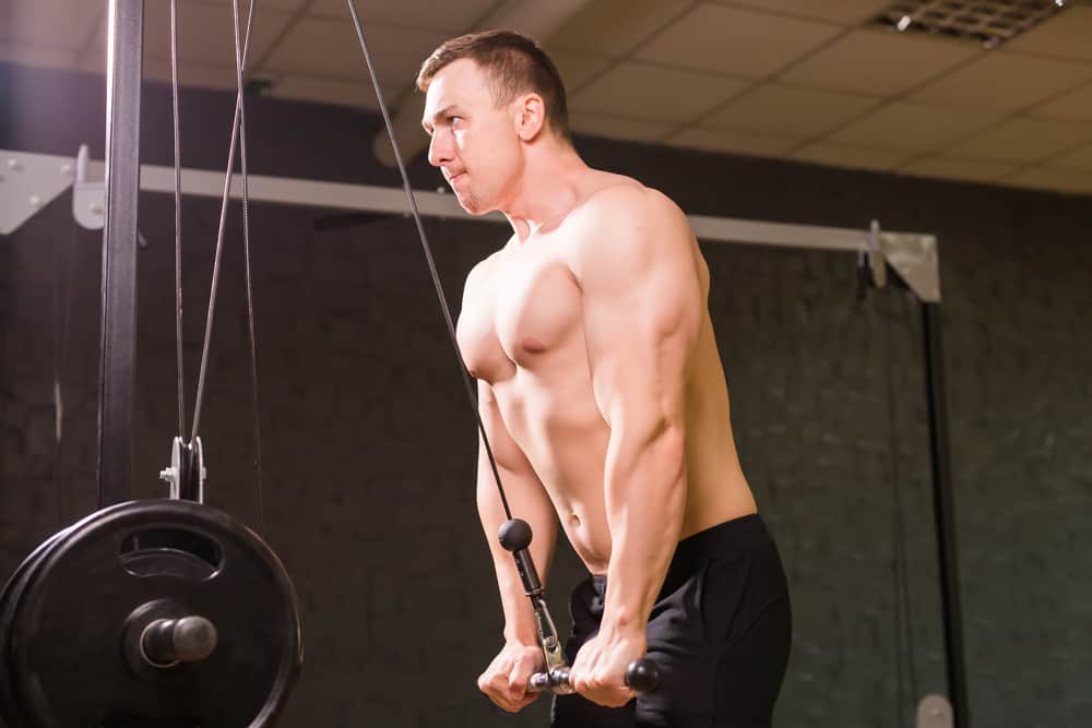 young man bar pushdown exercise in gym