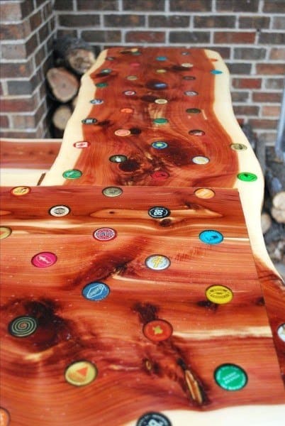 Unique wooden bar top embedded with colorful bottle caps, showcasing a rustic design.
