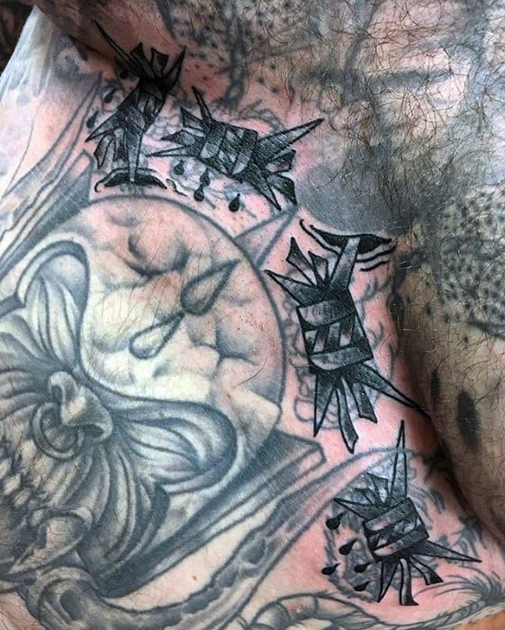 Close-up of blast over tattoos featuring abstract and barbed wire patterns in black and gray