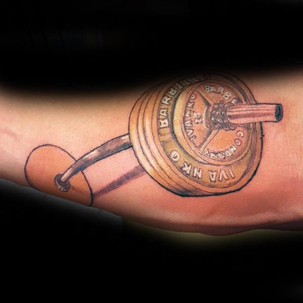 Detailed barbell tattoo with gold-toned weight plates and realistic shading, capturing a passion for lifting and gym culture.