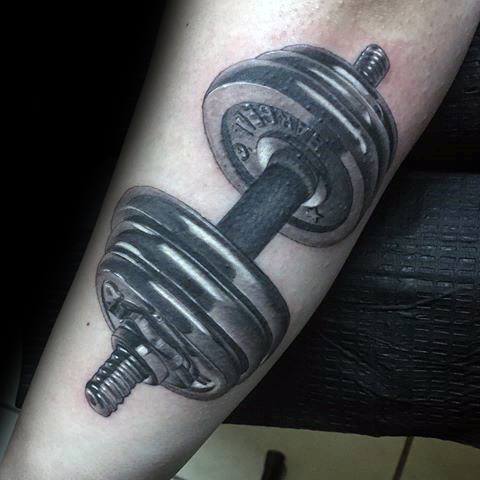 Hyper-realistic dumbbell tattoo in black and grey on forearm, showcasing dedication to fitness and weight training.