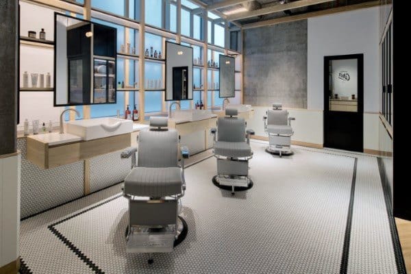 Minimalist barbershop with Scandinavian-style design, light wood accents, and tiled flooring.