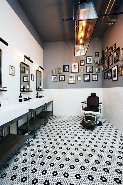 Barbershop with patterned tile flooring, framed wall art, and industrial-style lighting.