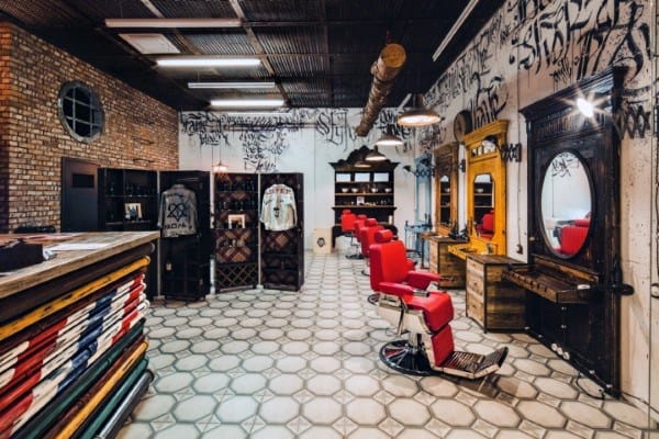 Barbershop with graffiti walls, red chairs, and industrial-style decor.