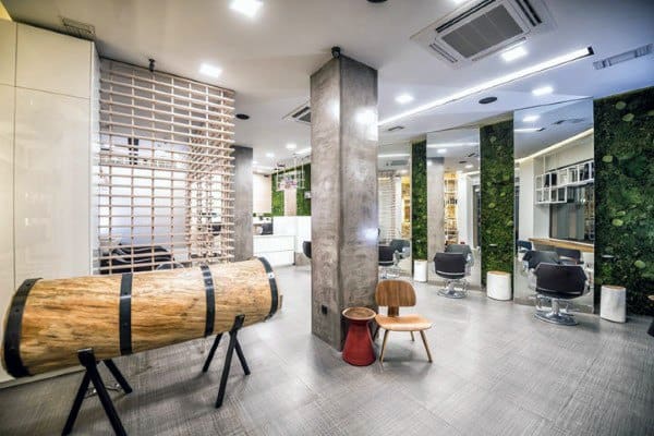 Contemporary barbershop with green wall accents, modern decor, and minimalist seating arrangement.