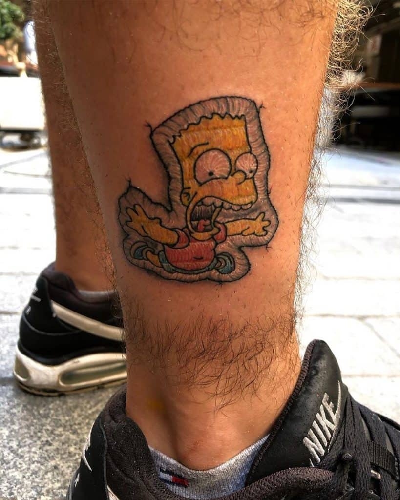 Patch-style tattoo of a yellow-haired cartoon boy, crafted with detailed stitched textures to resemble embroidery.