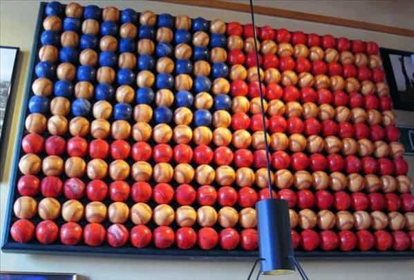 Wall art made of baseballs painted in red, white, and blue arranged to resemble the American flag