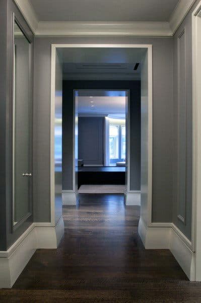 Modern hallway with dark wood floors and sleek gray baseboard moulding.