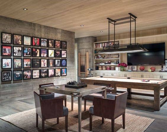 Basement game room with pool table, chess table, album art wall, and modern rectangular pendant light.