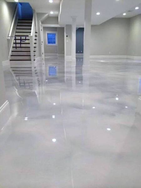 A basement with a shiny concrete floor, neutral walls, and stairs leading upwards