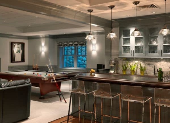 Stylish room with a bar, pool table, and framed jersey on the wall; modern lighting and decor