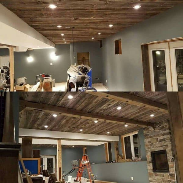 Rustic basement with wood plank ceiling, recessed lighting, and stone fireplace in progress.