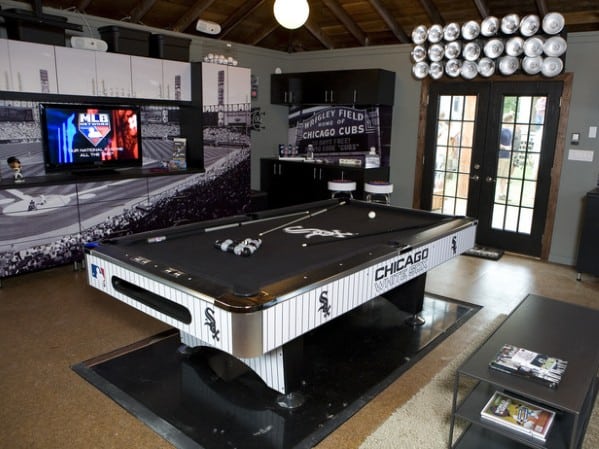 Chic man cave with a Chicago baseball pool table, TV, and a baseball cap display on the wall
