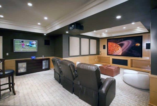 Home theater basement with recessed ceiling, leather recliners, large screen, and ambient lighting.
