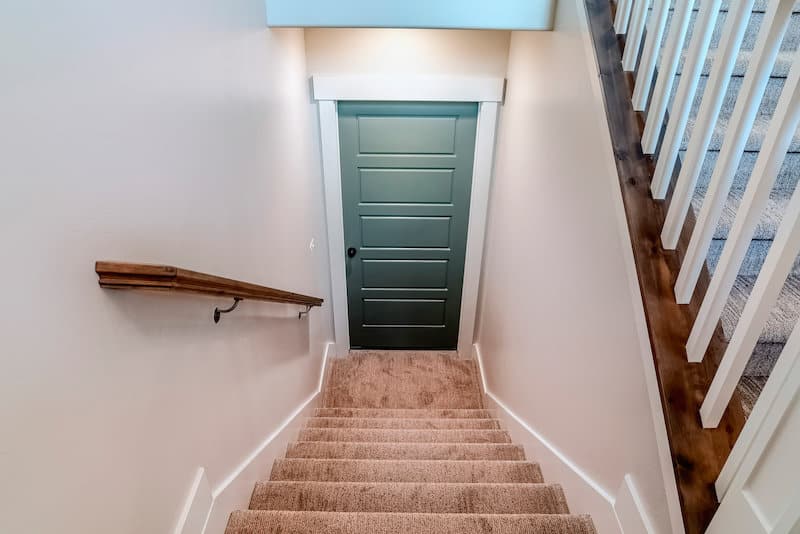 basement stairs leading to green door