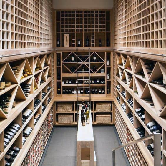 A well-organized wine cellar with wooden shelves filled with wine bottles and wicker baskets