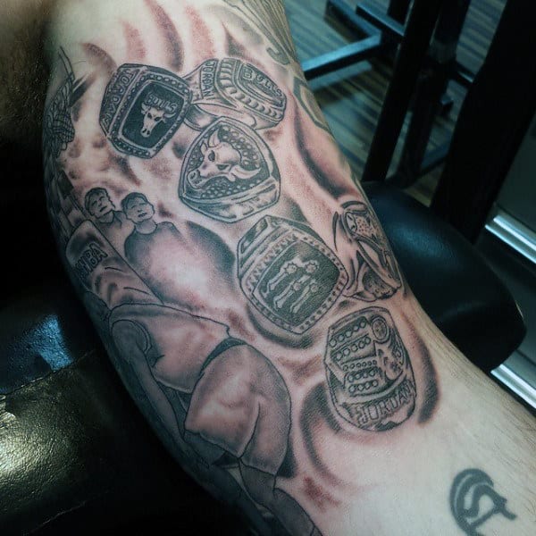 Tattoo of multiple championship rings and athletes on an arm