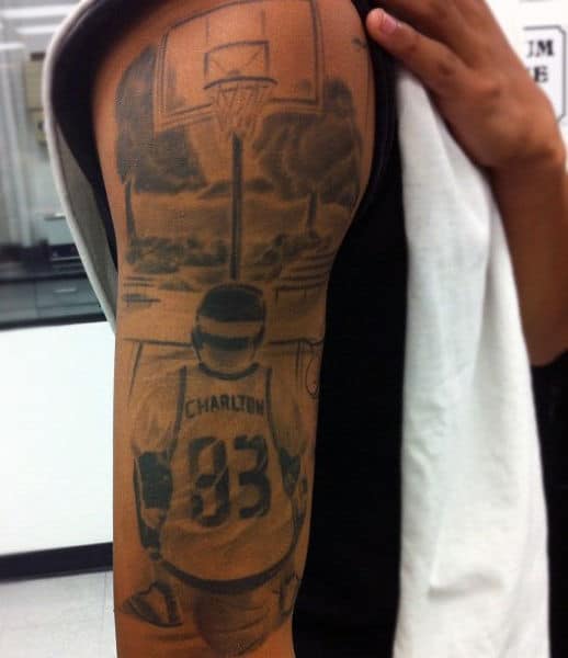 A detailed tattoo of a basketball player poised to shoot toward a hoop with "Charlton 83" emblazoned on the jersey
