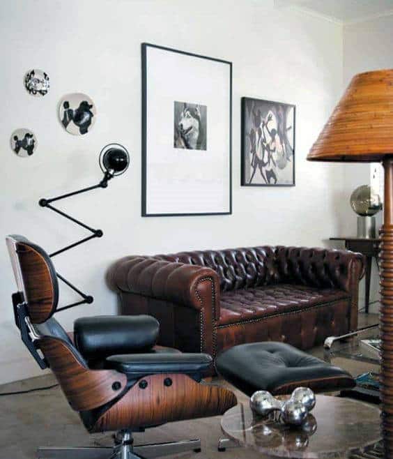 Living room with a brown leather Chesterfield sofa, modern lounge chair, and wall art.