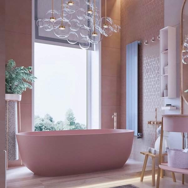 Bubble cluster chandelier above a pink freestanding tub with blush tiles, gold fixtures, and soft wooden accents.