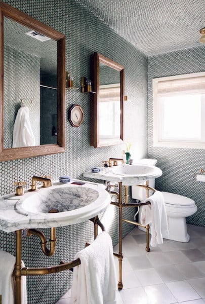 Vintage bathroom with mosaic tile ceiling, marble sinks, and brass fixtures.