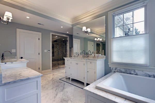 Spacious bathroom with marble flooring, large mirrors, double vanity, and moulded ceiling.
