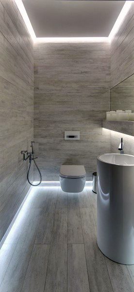 Minimalist bathroom with LED strip lighting, floating toilet, and cylindrical sink.