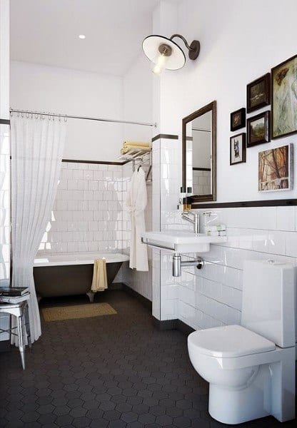 Vintage-style bathroom with black hexagon floor tiles, white subway walls, and framed artwork.