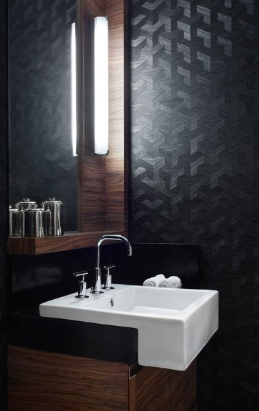 Bathroom with black textured wallpaper, white sink, and modern lighting.
