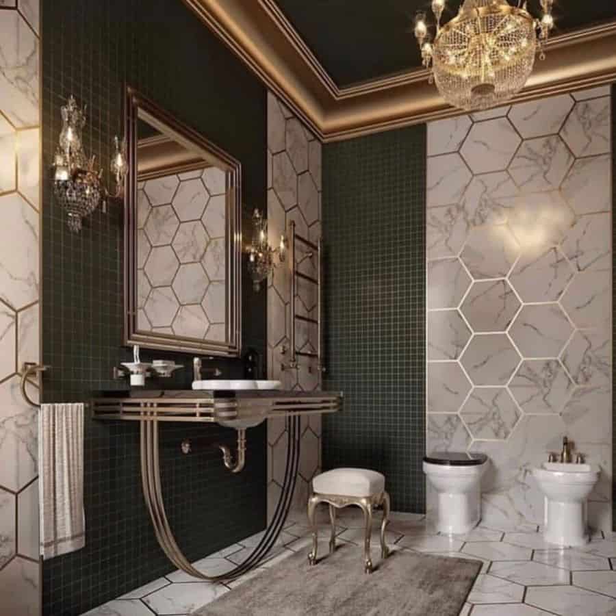 Luxurious bathroom with chandelier lighting, hexagonal wall tiles, and gold accents.