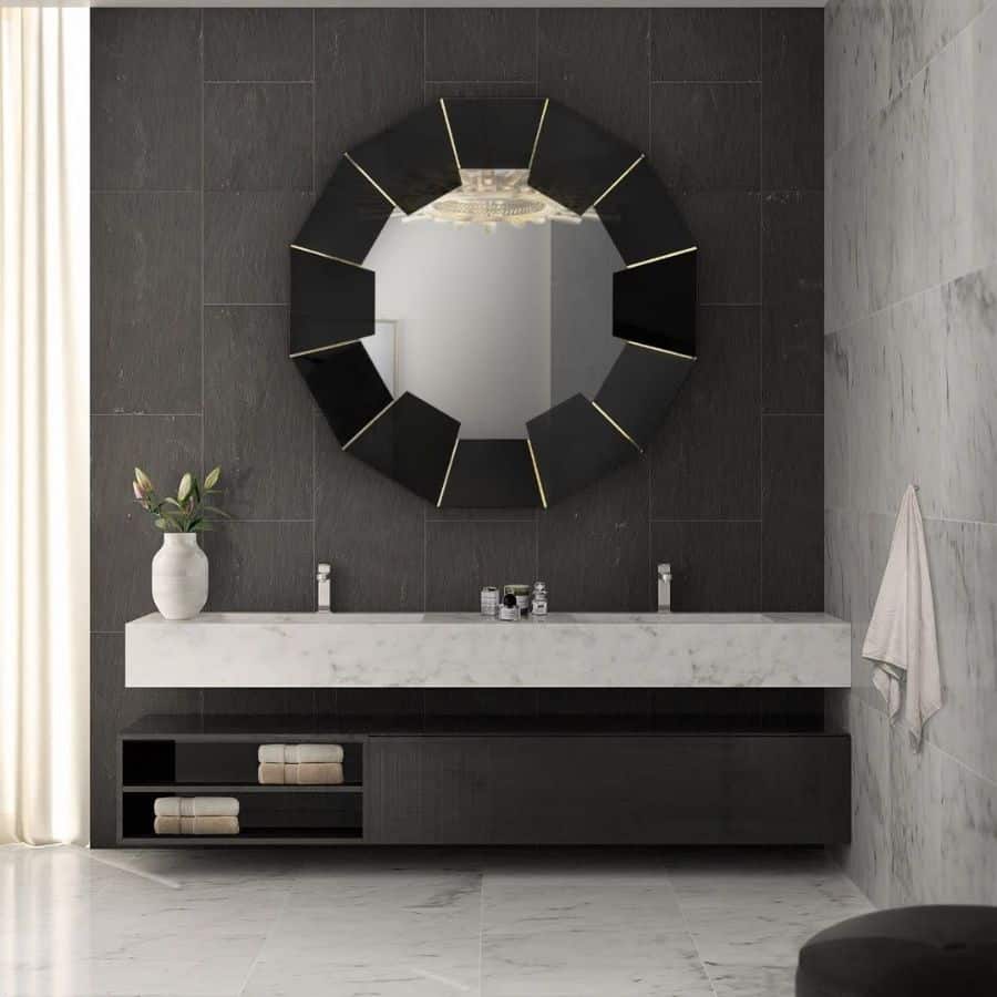 Modern bathroom with large floating vanity, decorative circular mirror, and marble accents.