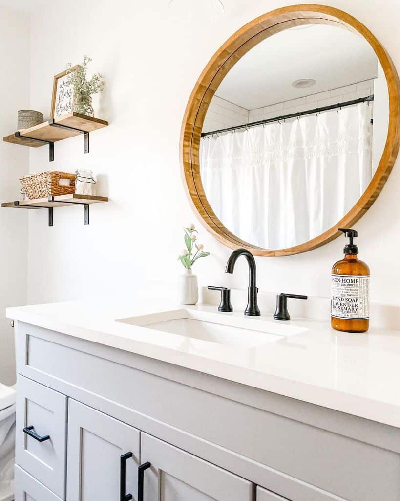 modern farmhouse bathroom with gray cabinet and wood frame wall mirror