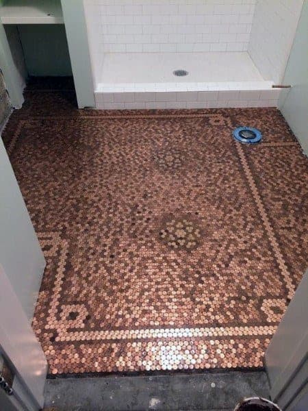 Bathroom with penny tile floor featuring a bordered pattern design and white tiled shower area.