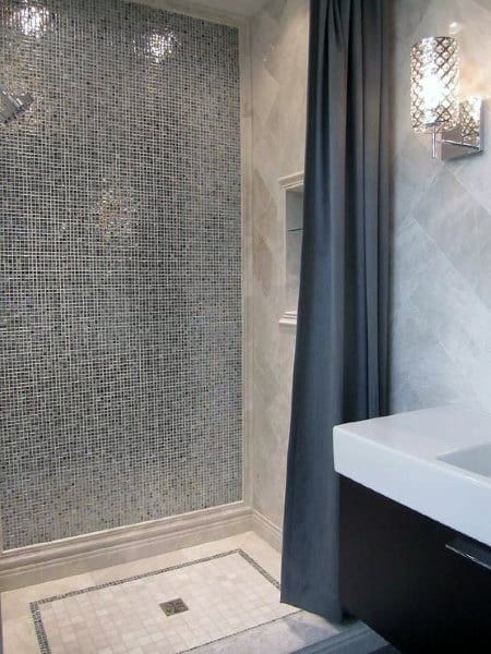Silver mosaic tile shower with dark curtain and modern vanity sink.